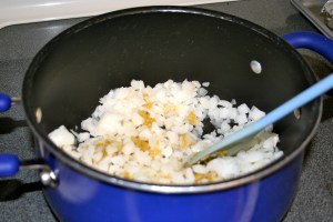 In a large pot, cook onions, green chiles and garlic in olive oil until onions are soft and transparent. Add cumin and coriander and cook for a few more minutes. Remove from heat.
